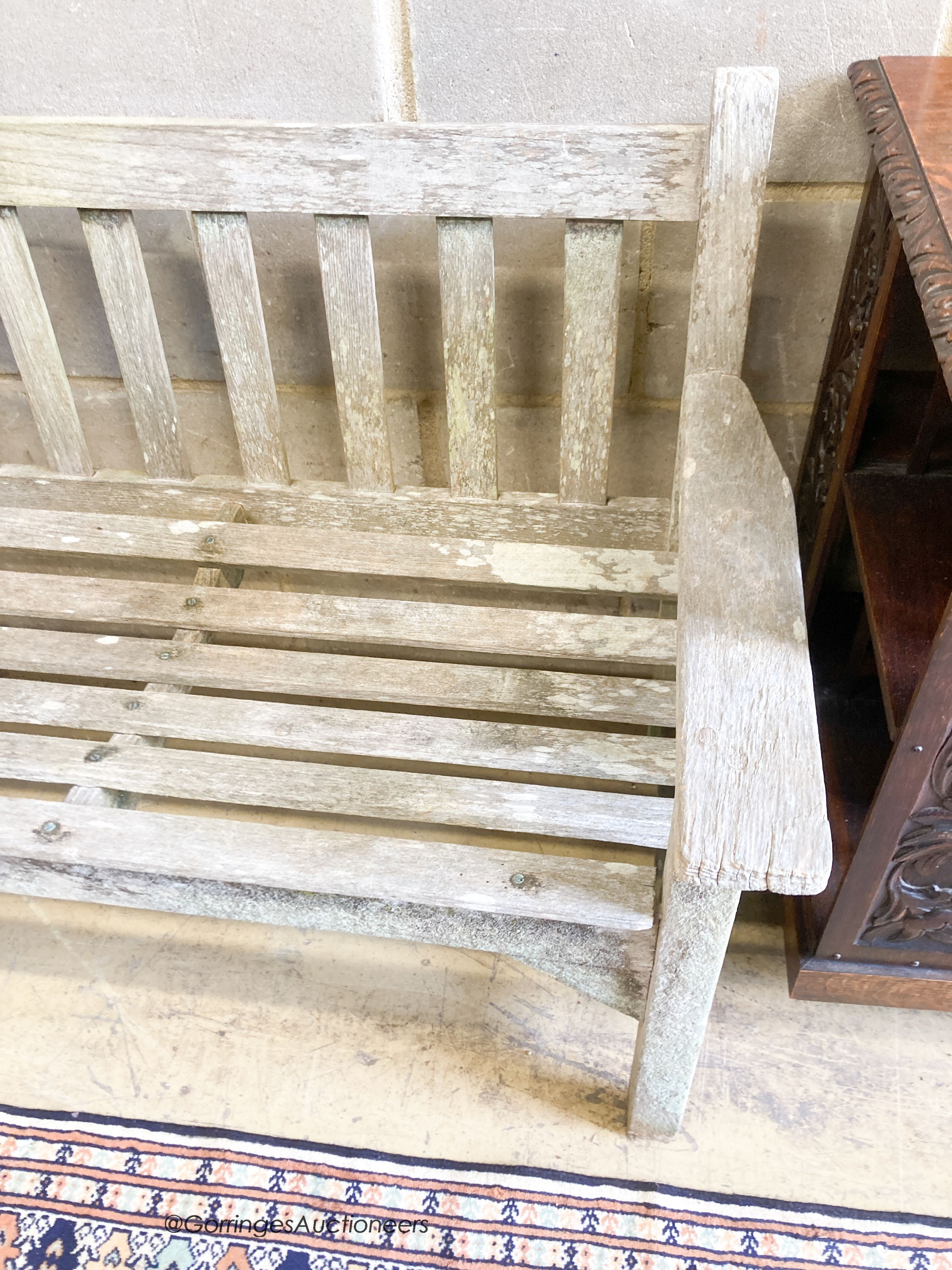 A weathered teak garden bench, length 159cm, depth 56cm, height 81cm